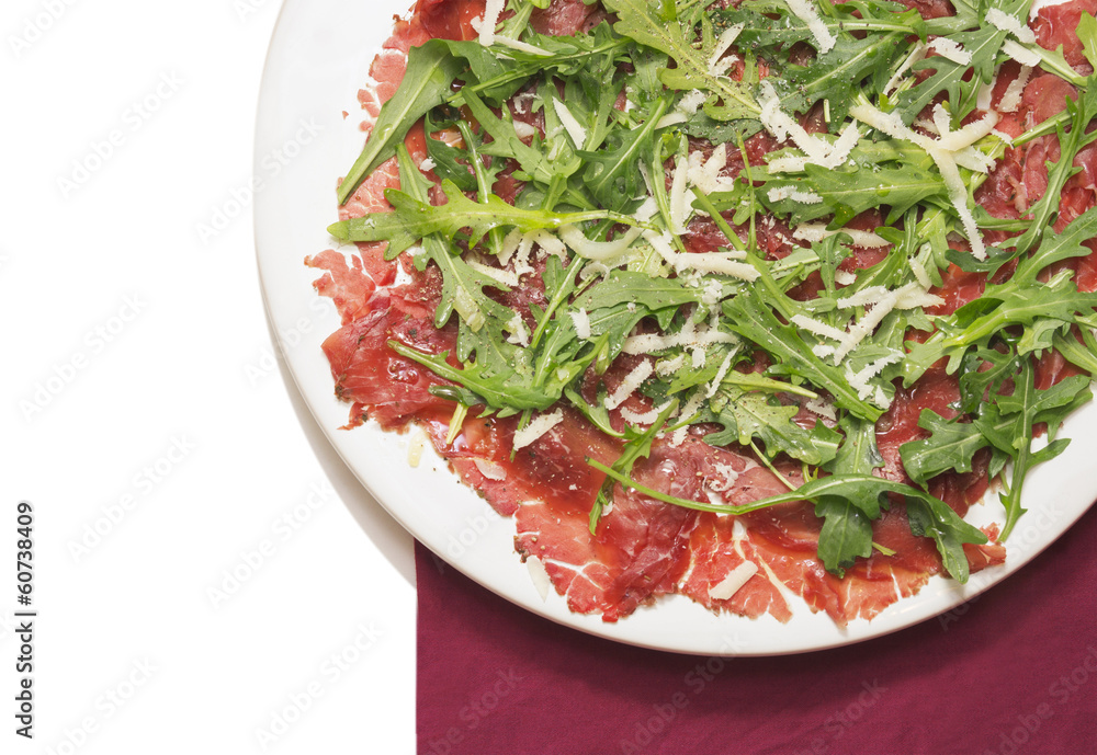 Carpaccio of beef with rucola and Parmesan on red napkin Carpaccio of beef with rucola and Parmesan on red napkin