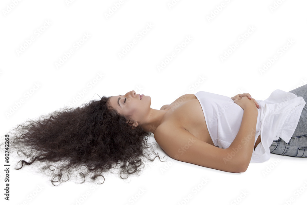Naklejka premium Side View of a female fashion model lying on floor against white