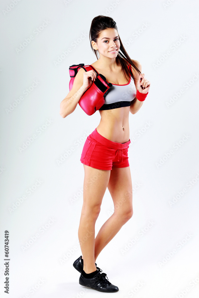 woman standing with boxing gloves on gray background woman standing with boxing gloves on gray background
