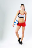 woman standing with soccer ball on gray background