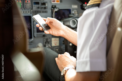 Pilot Using Cell Phone In Cockpit photo