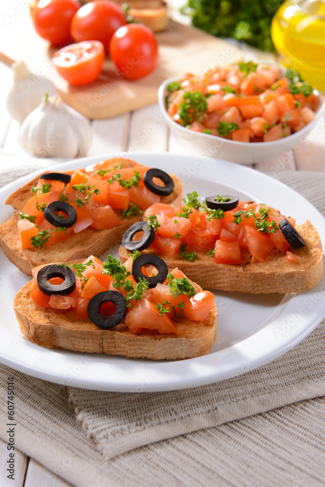 Delicious bruschetta with tomatoes on plate on table close-up Delicious bruschetta with tomatoes on plate on table close-up