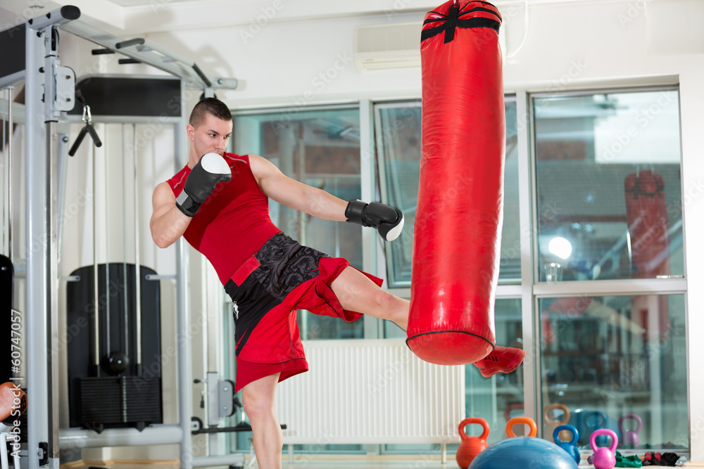 Man practicing some kicks with a punching bag