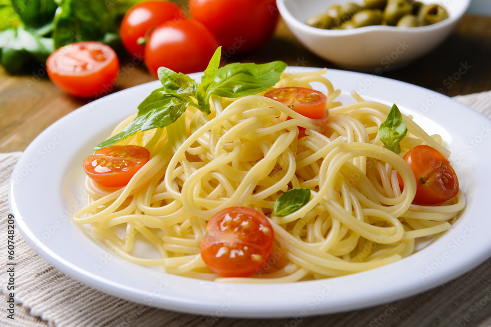Delicious spaghetti with tomatoes on plate on table close-up Delicious spaghetti with tomatoes on plate on table close-up