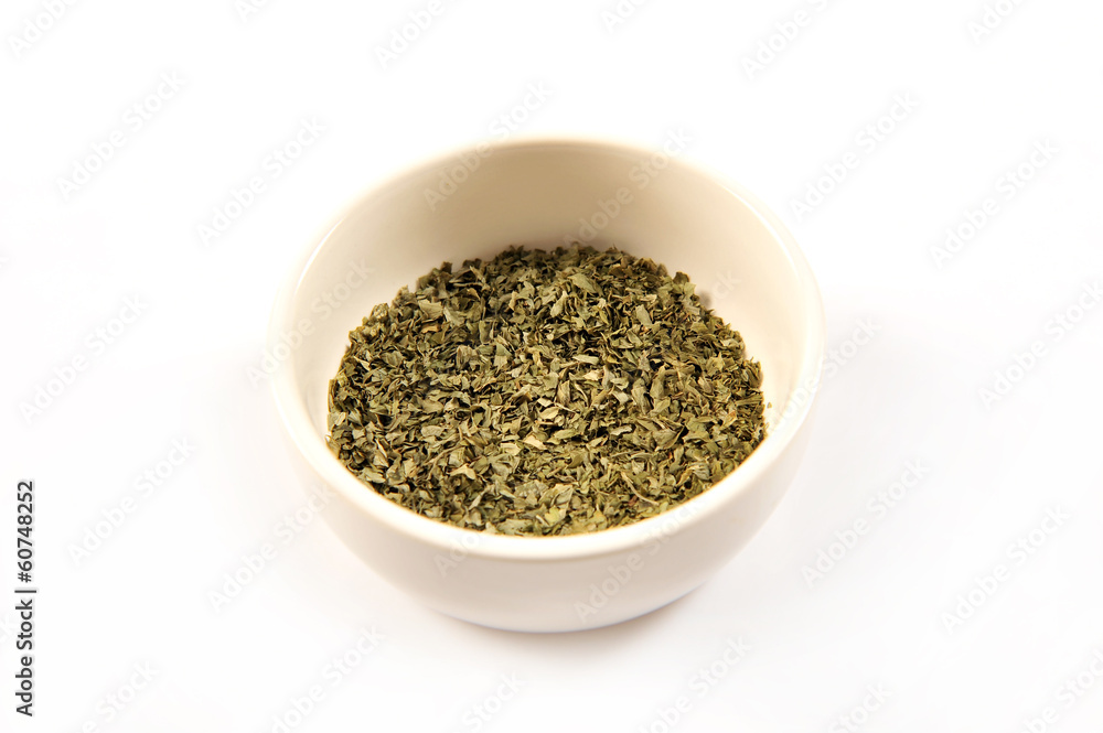 Dried oregano in a white ceramic bowl Dried oregano in a white ceramic bowl