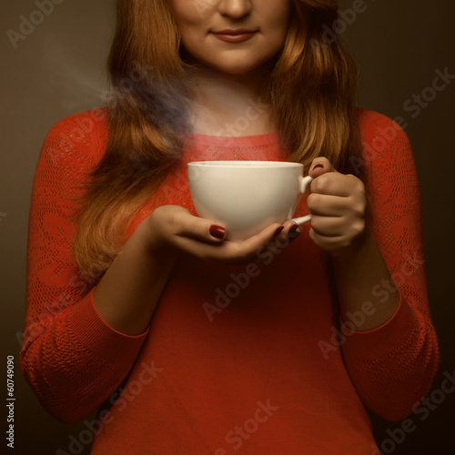 woman holding hot cup and smiles