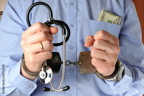 Canvas Print Man holds his hands with stethoscope in handcuffs before itself