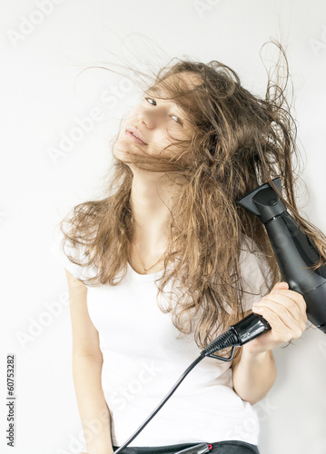 girl with long hair and a hairdryer in the studio