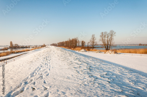 Snowy Dutch dike with footprints