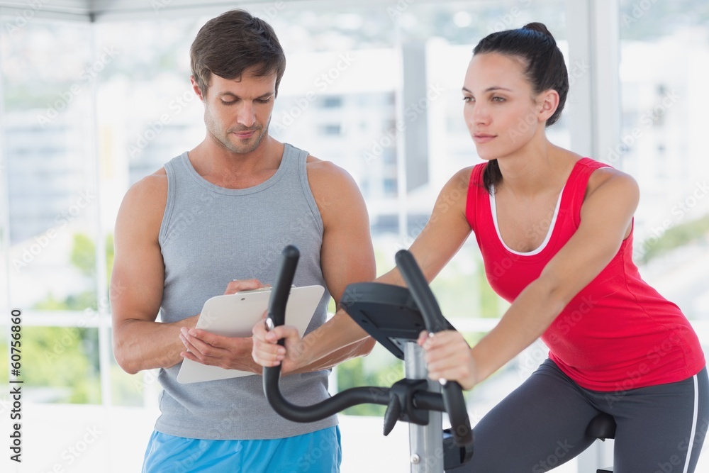 Woman with male instructor working out at spinning class Woman with male instructor working out at spinning class