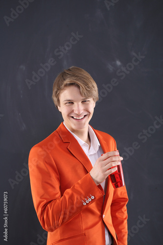 Radosny chłopak w pomarańczowej marynarce z kubkiem kawy