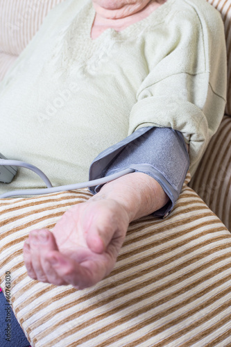 senior person using blood pressure monitor