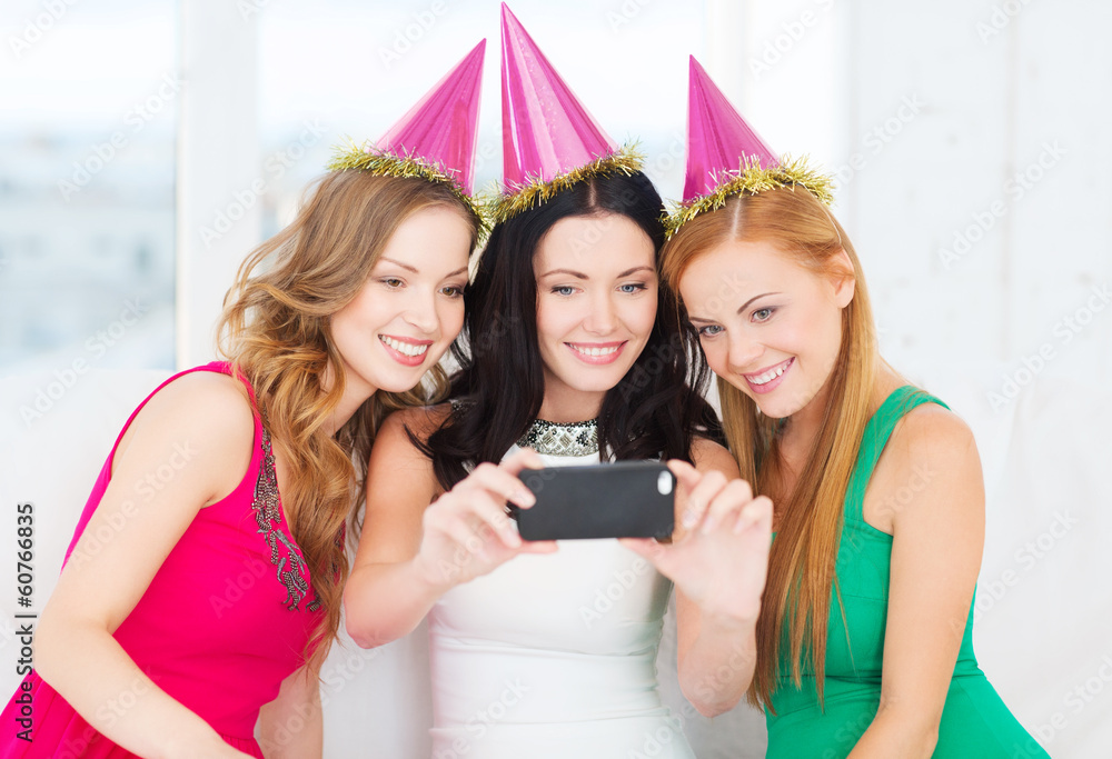 three smiling women in hats having fun with camera three smiling women in hats having fun with camera