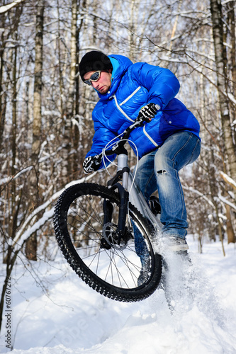 Cyclist riding on a mountain bike in the snow winter forest