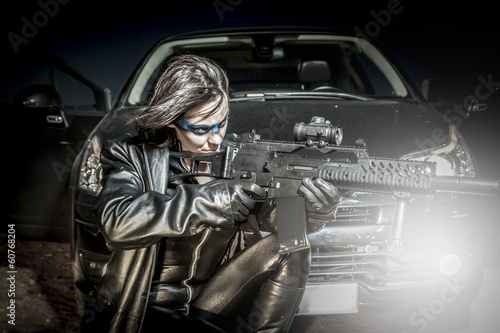 Fire, Dangerous woman dressed in black latex, armed with gun. co © Fernando Cortés