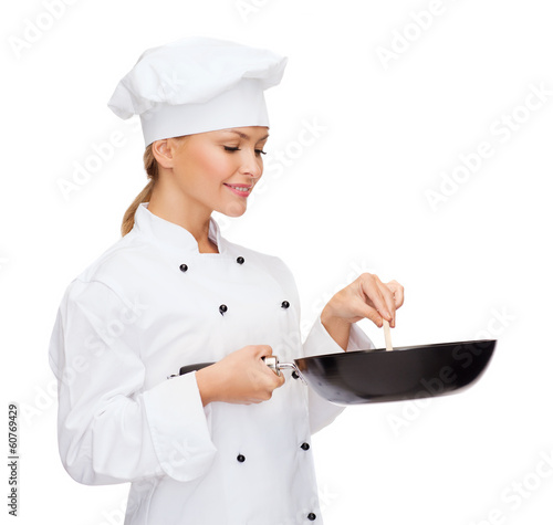 smiling female chef with pan and spoon