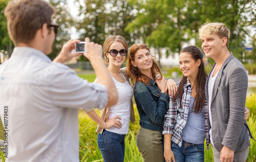 teenagers taking photo digital camera outside