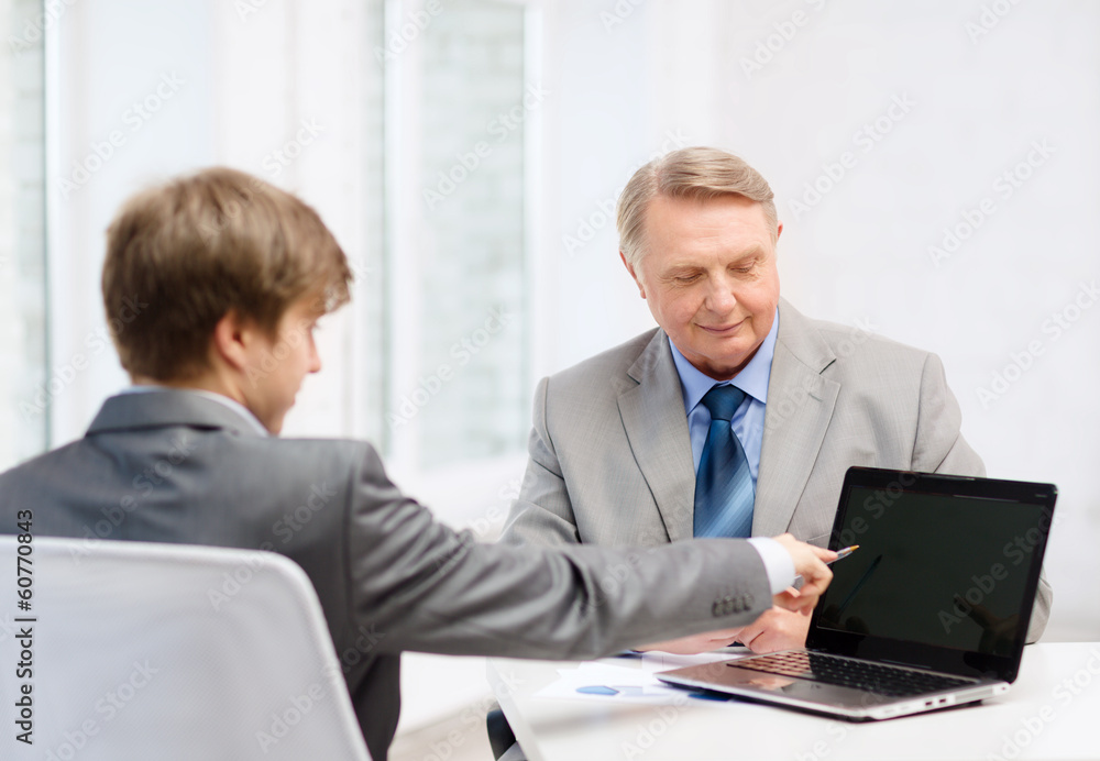 older man and young man with laptop computer older man and young man with laptop computer