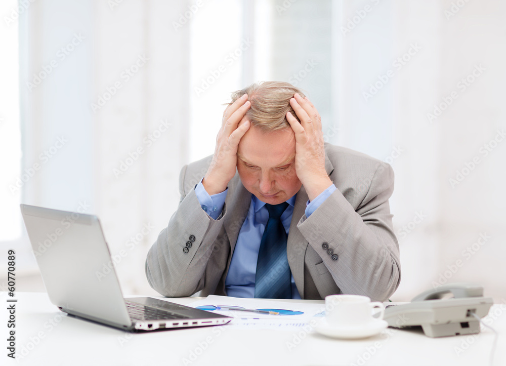 upset older businessman with laptop and telephone upset older businessman with laptop and telephone