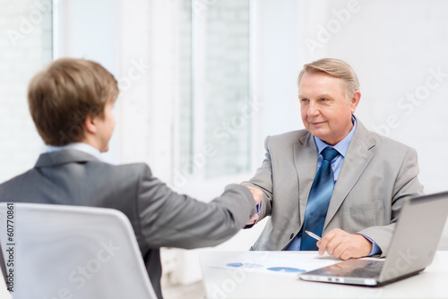 Wallpaper Mural older man and young man shaking hands in office Torontodigital.ca