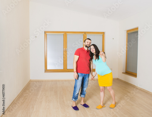 Pregnant mother and happy father in new house
