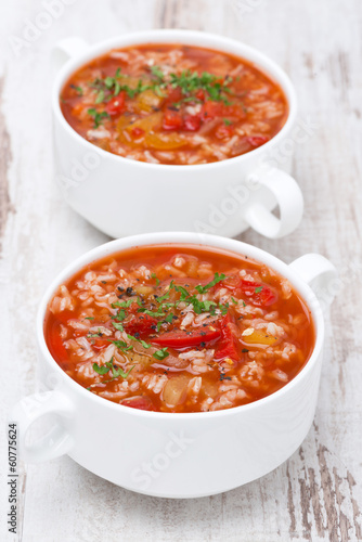tomato soup with rice and vegetables on white wooden table