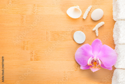 branch lilac orchid, shells and white towels on bamboo wooden