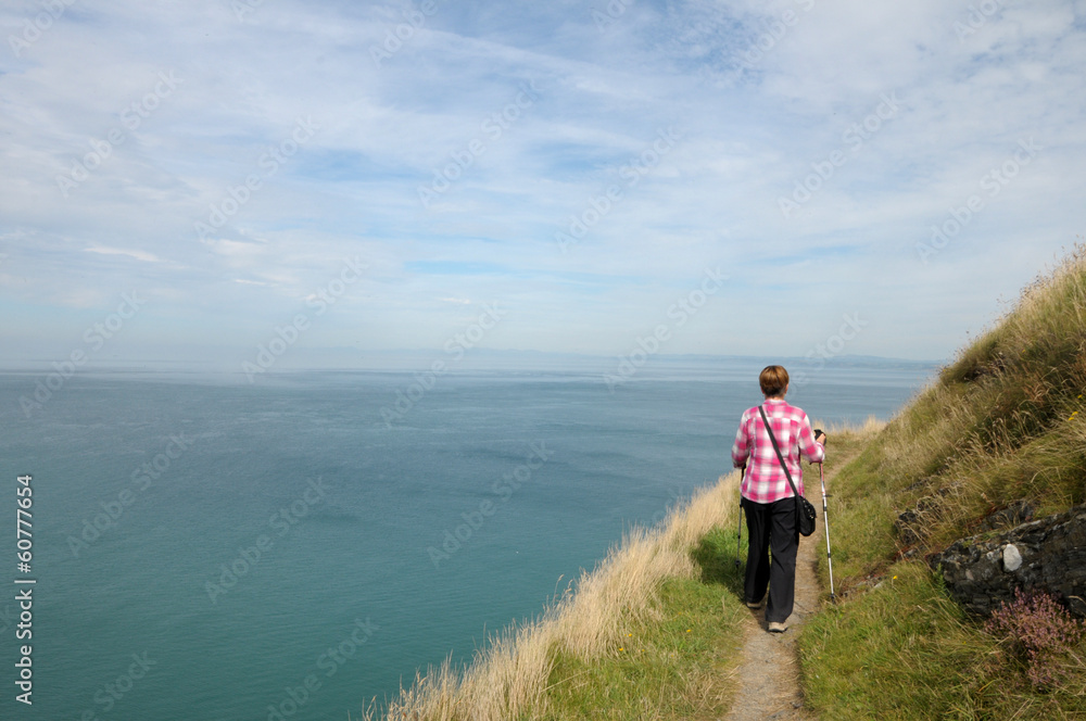Walker on coastal path above Cardigan Bay