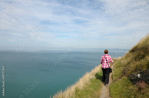 Walker on coastal path above Cardigan Bay