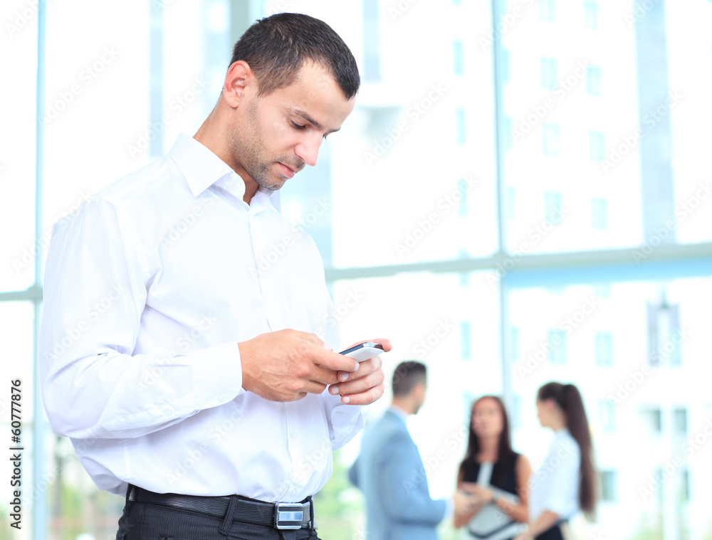Fototapeta premium Handsome businessman using a smartphone
