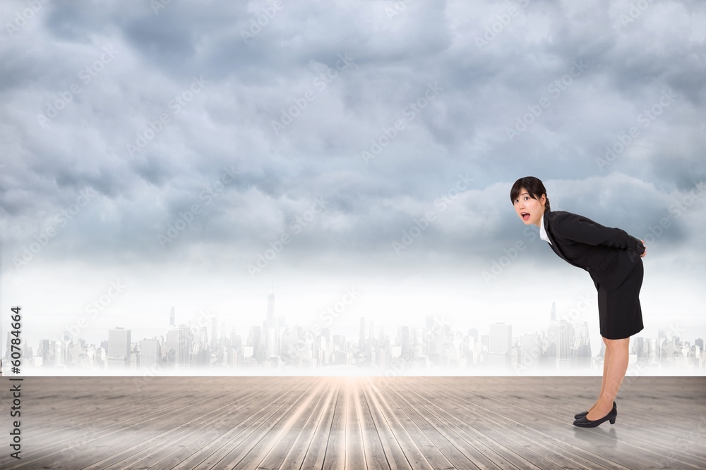 Composite image of surprised businesswoman bending Composite image of surprised businesswoman bending