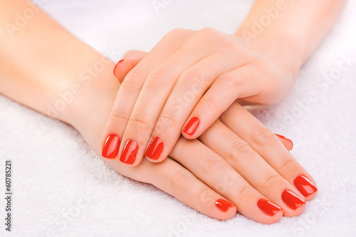 red manicure on the white towel