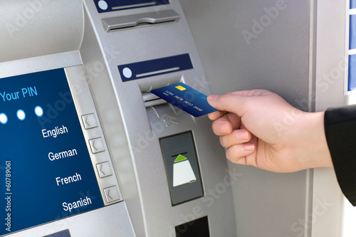 men hand businessman puts credit card into ATM