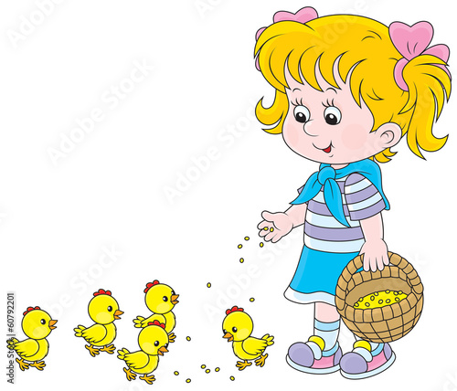 Little girl feeding small yellow chickens