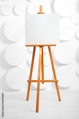 wooden easel with blank canvas in the studio