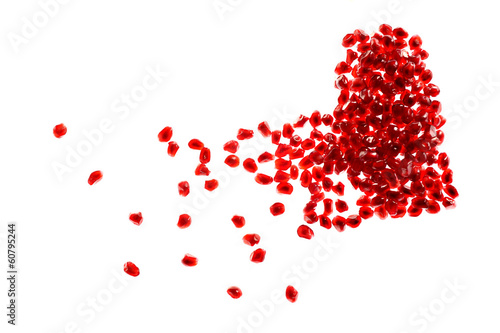 Red broken heart made of pomegranate seeds on white background