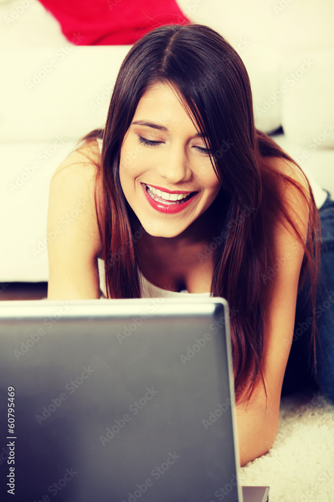 Young female lying on floor using laptop. Young female lying on floor using laptop.