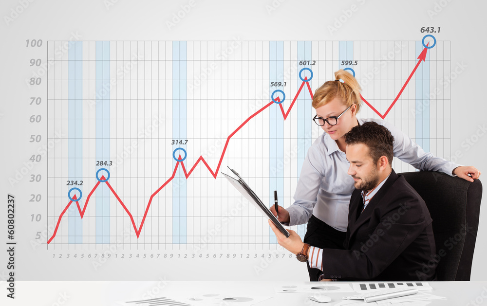 Businessman and businesswoman calculating stock market with risi