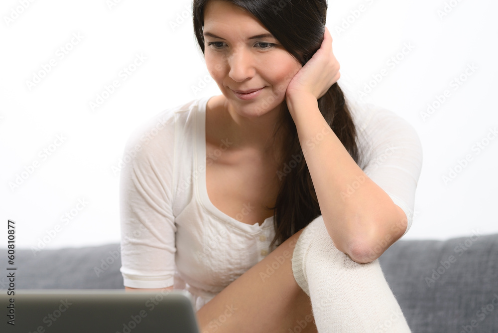 Sexy Frau sitzt mit ihrem Laptop auf dem Sofa Sexy Frau sitzt mit ihrem Laptop auf dem Sofa