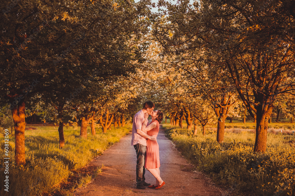 Fototapeta premium Portrait of young couple in flowering park