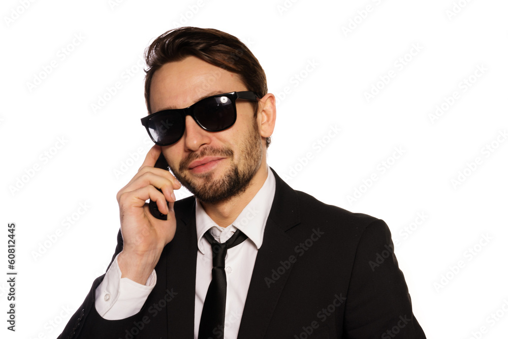 Smiling businessman in sunglasses on his mobile Smiling businessman in sunglasses on his mobile