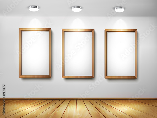 Empty wooden frames on wall with spotlights and wooden floor. Ve