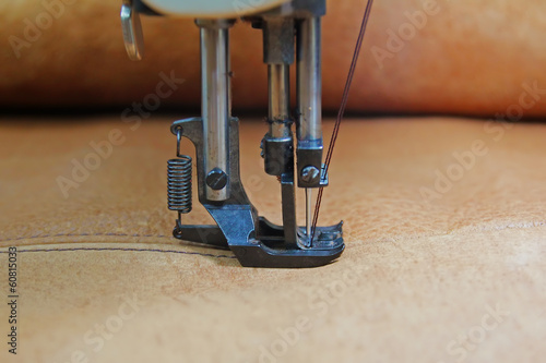 Closeup of sewing machine working part with leather