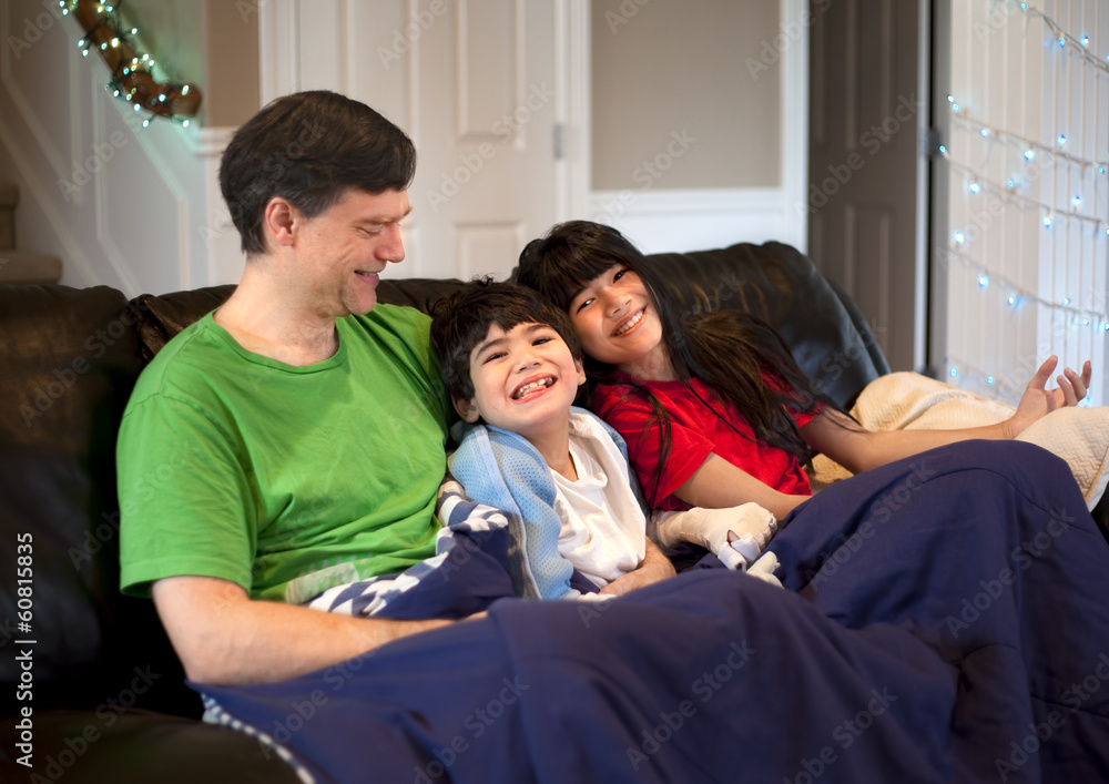 Family with disabled boy relaxing together on leather couch