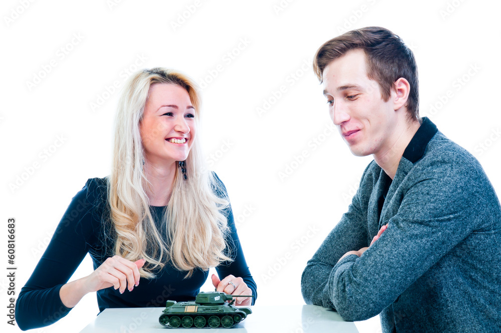 young beautiful woman gives a man a toy tank