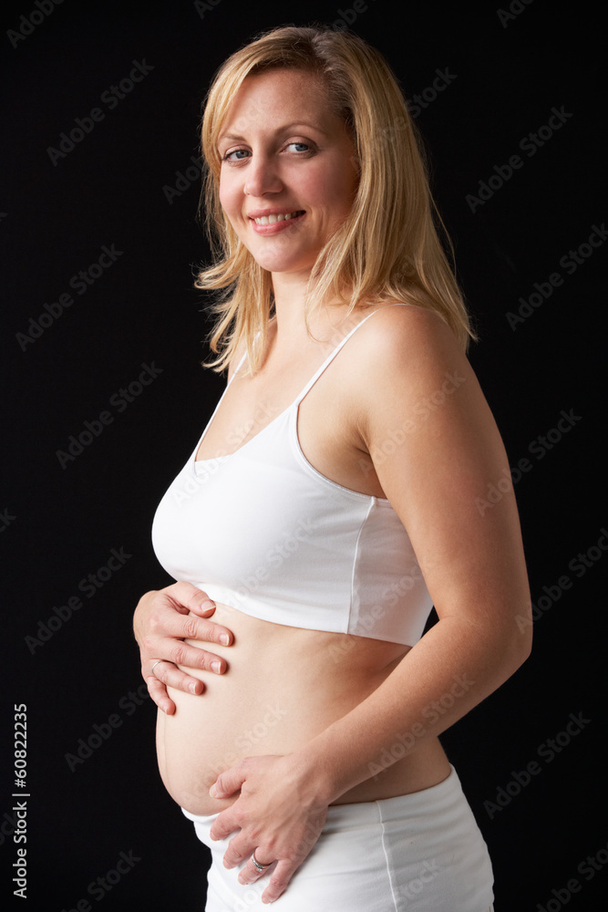 Portrait Of 4 months Pregnant Woman Wearing White On Black Backg Portrait Of 4 months Pregnant Woman Wearing White On Black Backg