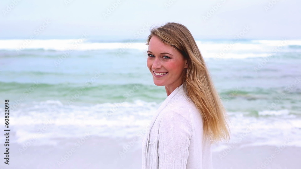 Happy blonde turning and smiling at camera on the beach Happy blonde turning and smiling at camera on the beach