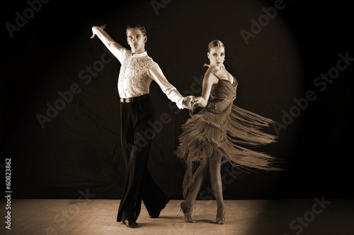 dancers in ballroom against on black