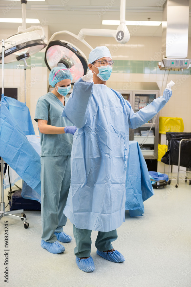 Nurse Assisting Surgeon With Sterile Gown Nurse Assisting Surgeon With Sterile Gown