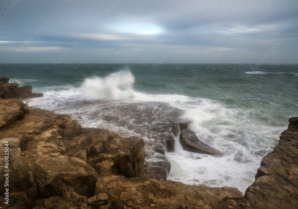 Landscape of waves crashing onto rocks during beautiful Winter's